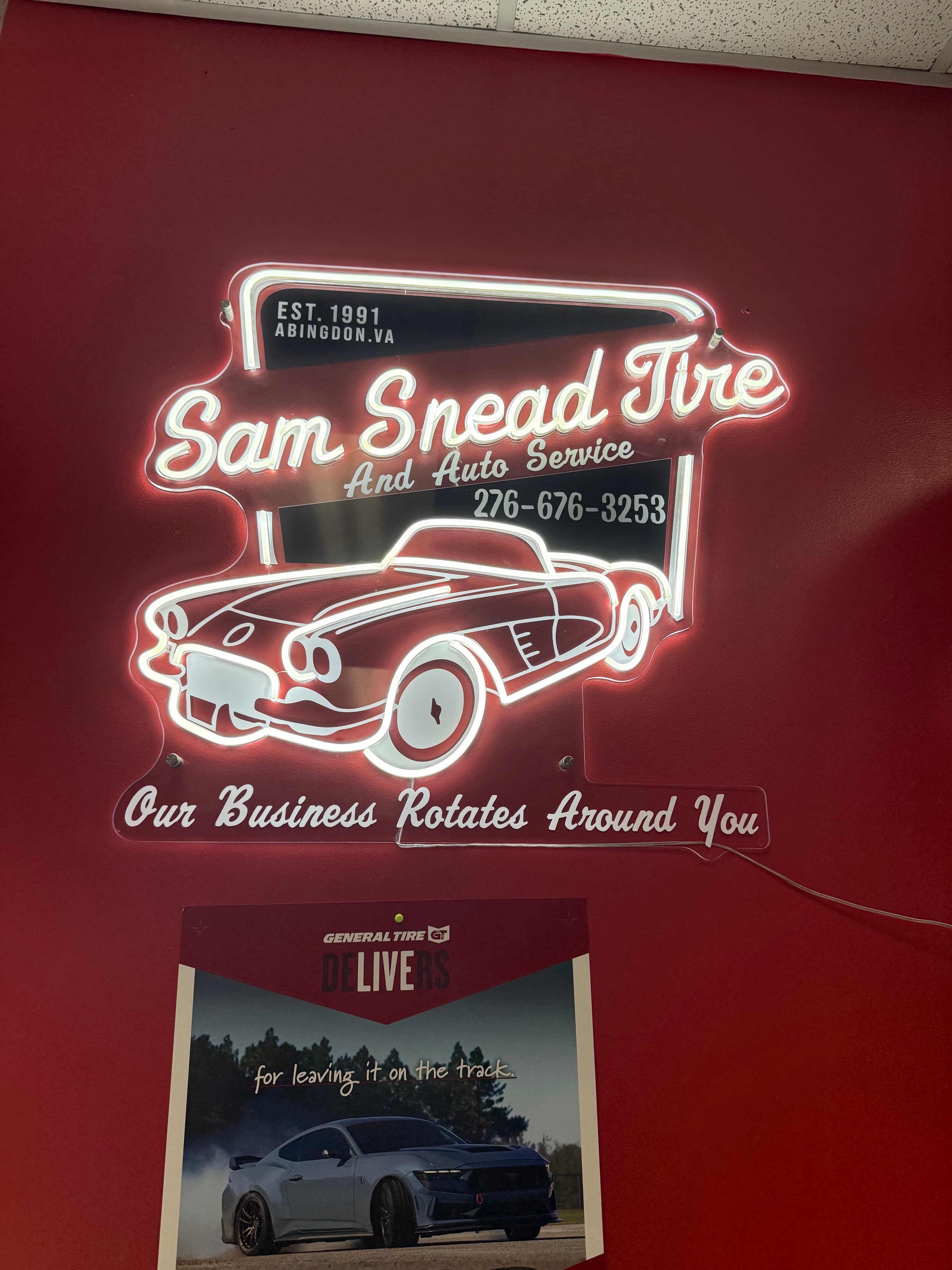 Illuminated Sam Snead Tire sign inside the shop