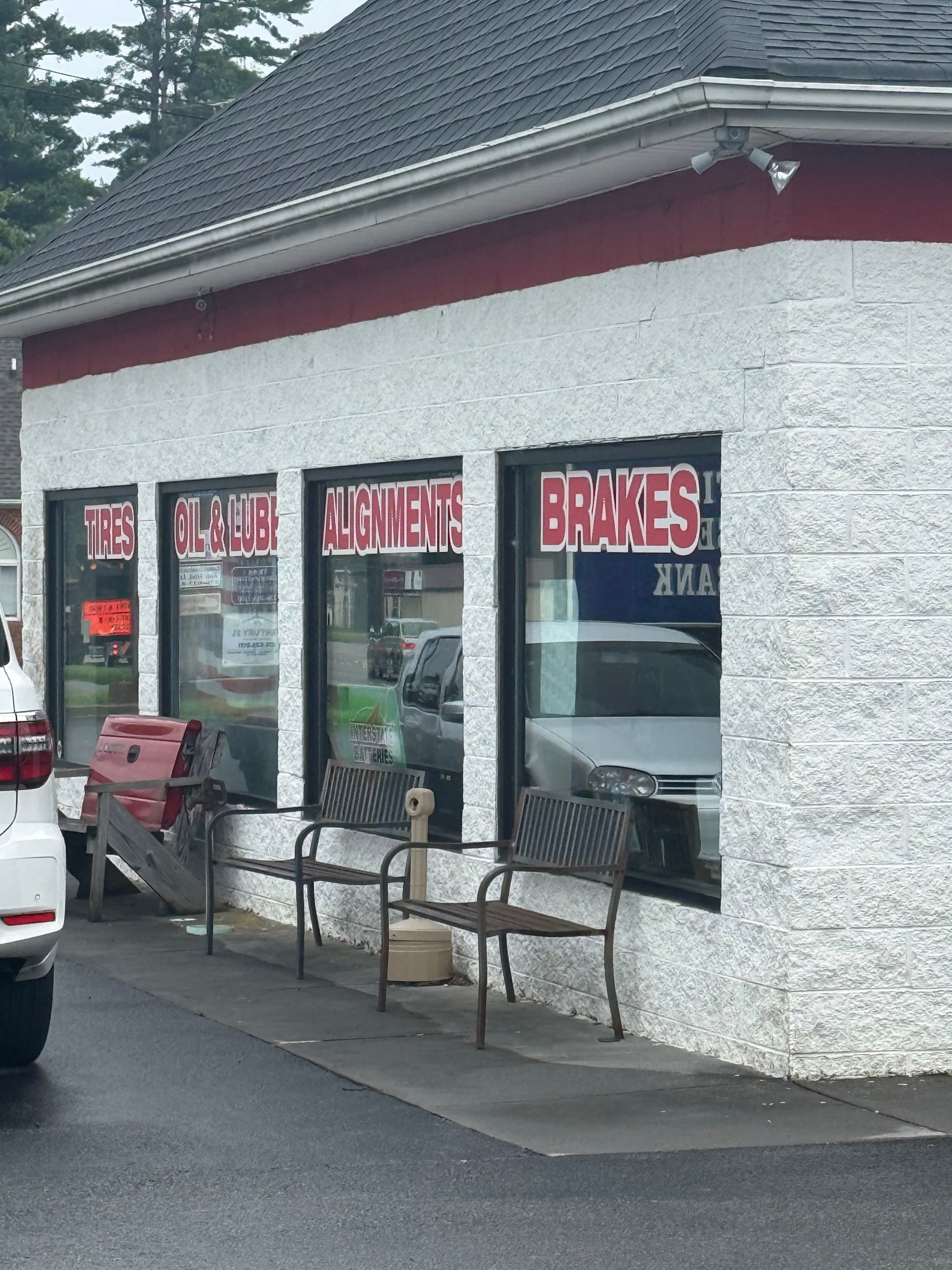 Sam Snead Tire storefront windows advertising tires, oil and lubrication, alignments, and brakes