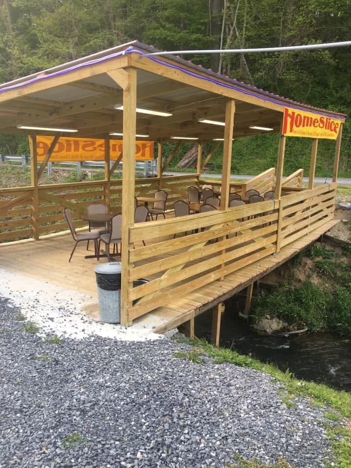 Covered outdoor dining deck at HomeSlice Cafe built above the creek