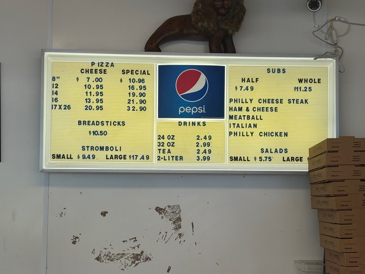 The illuminated Lyon's Den menu board inside the restaurant